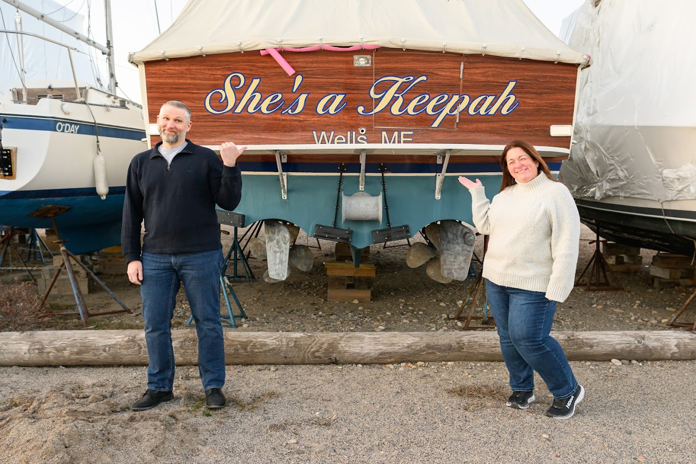 Brad and Julie in front of a boat named "she's a keepah"