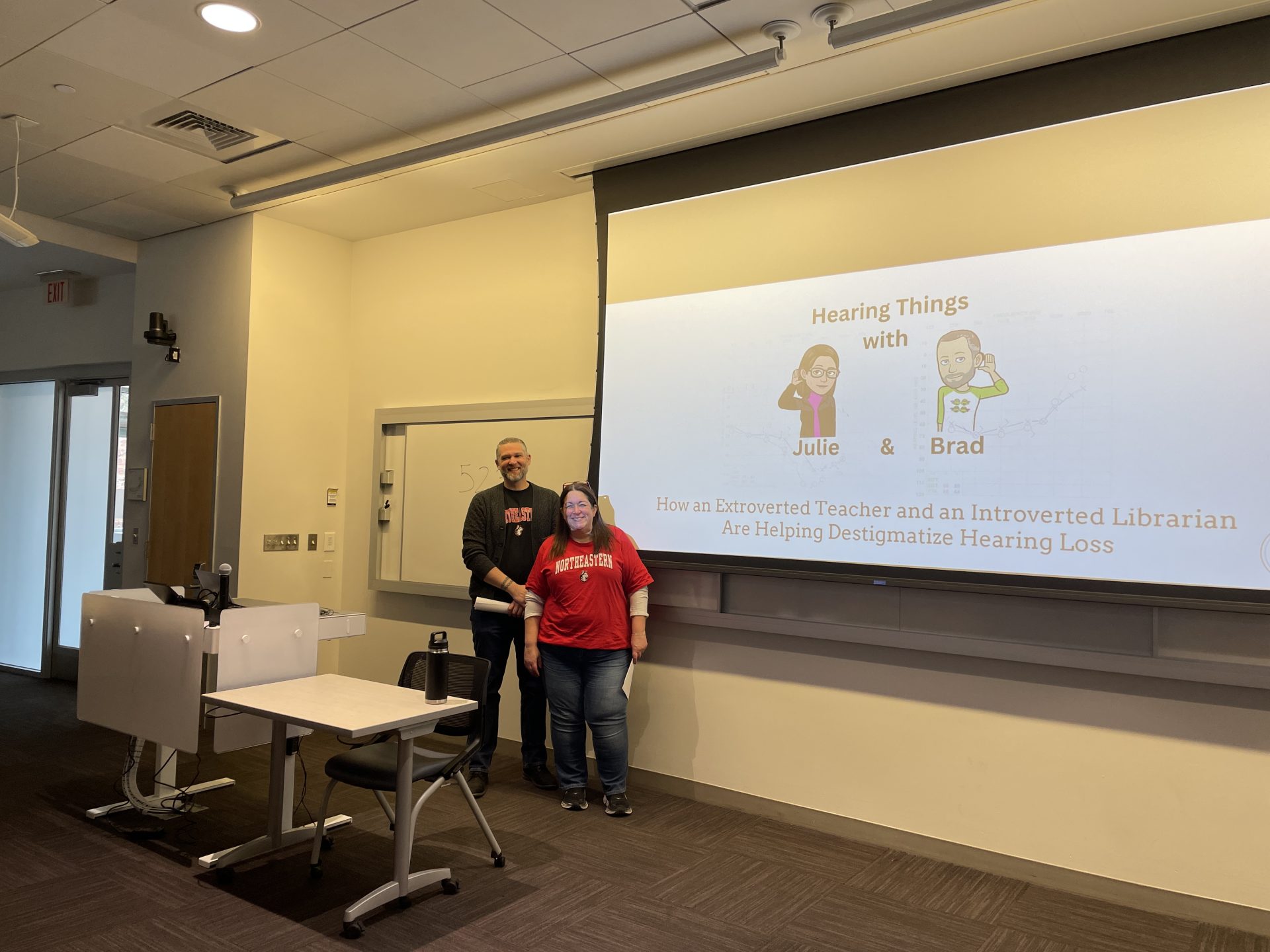 Brad and Julie in front of a screen in a classroom at NEU