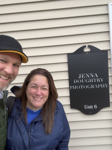 Brad and Julie in front of Jenna Dougherty Photography's sign.